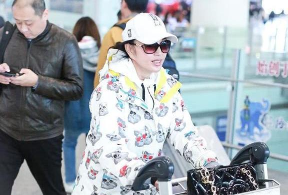刘晓庆现身机场身穿卡通衣推行李,63岁的她卖
