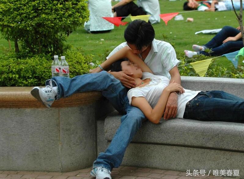 这对年轻小情侣在路边休息,女孩躺在男孩的怀中,这是他们最幸福的时刻