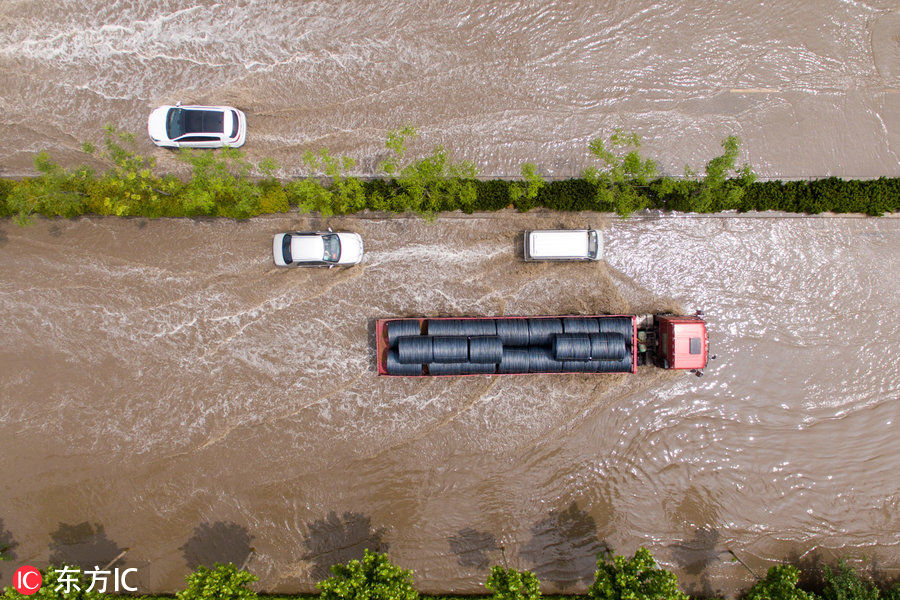 郑州大雨后车辆贴路边涉水前行 网友戏称“车船税真的没白交”!