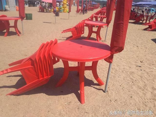 葫芦岛313海边鲜红的桌椅,细细的沙滩蓝蓝的天