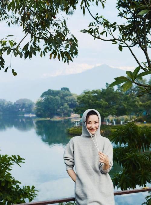 许晴不愧单身贵族，红大衣配长靴肆意大笑，51岁还有少女的娇俏