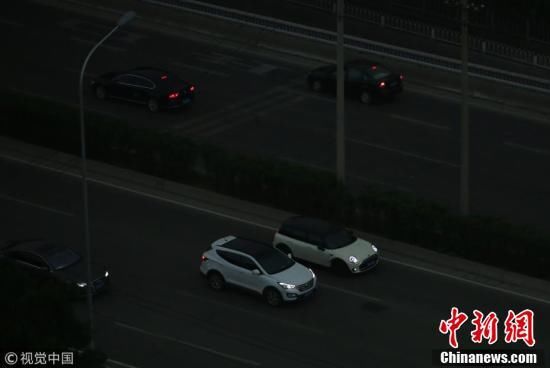 北京迎入夏后最大阵雨 民众雨中出行