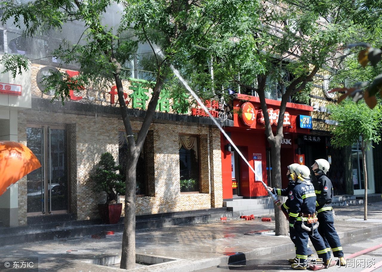 消防员前往餐馆灭火,工作人员向路面撒盐