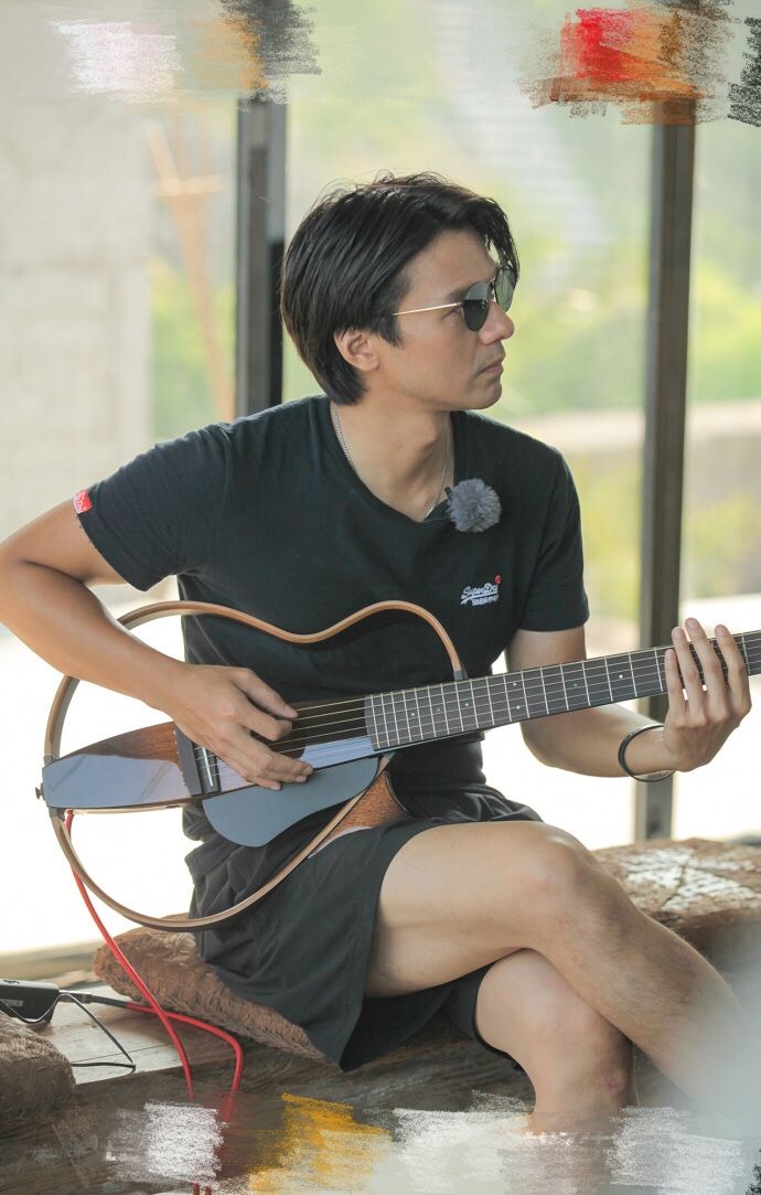 组图:冯德伦手拿吉他眼神专注 写词弹唱尽展侧