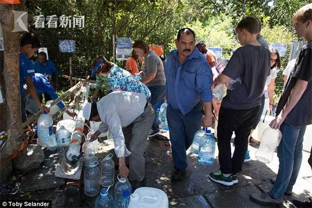 三年干旱终降雨 南非大妈欣喜若狂雨中洗澡洗车