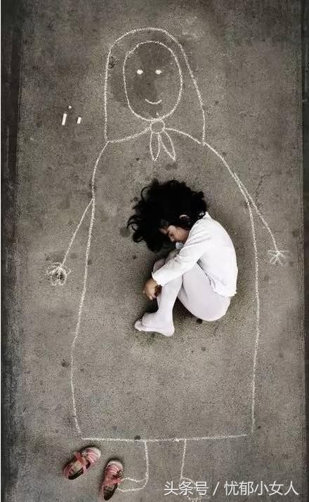 一个没有妈妈的小女孩,在孤儿院的水泥地面上,画了一个妈妈,她小心翼